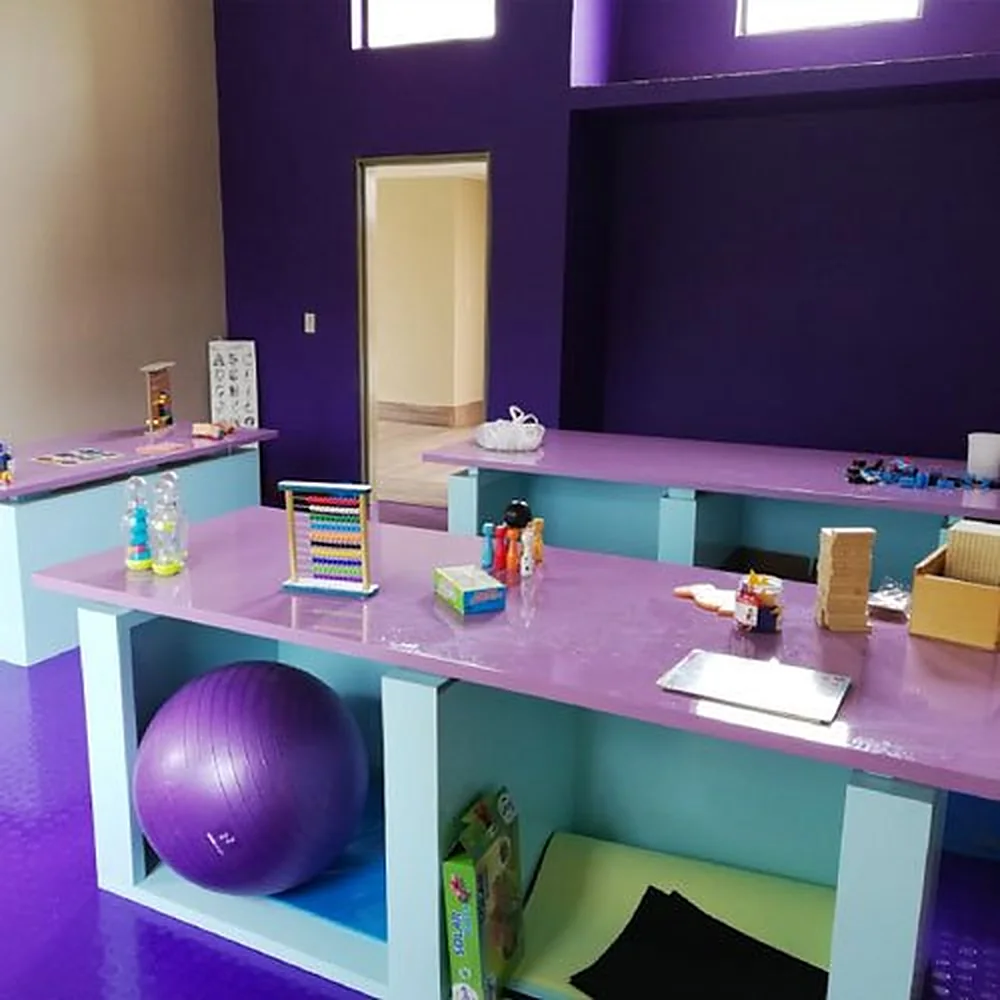 Aula con mesones de colores, material didáctico y balón de gimnasia