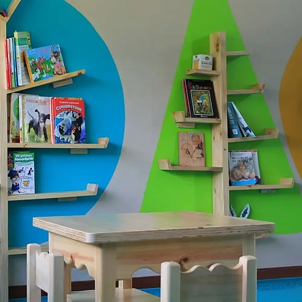 Rincón de lectura con libros infantiles en estanterías de colores