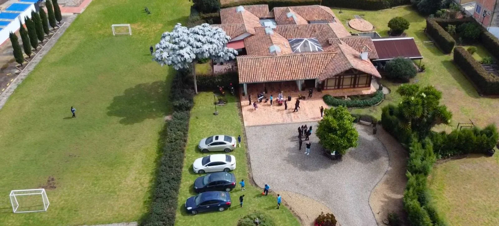 Vista aérea de la sede Chía: la casa de teja, los jardines, el campo de fútbol y los estudiantes en el patio