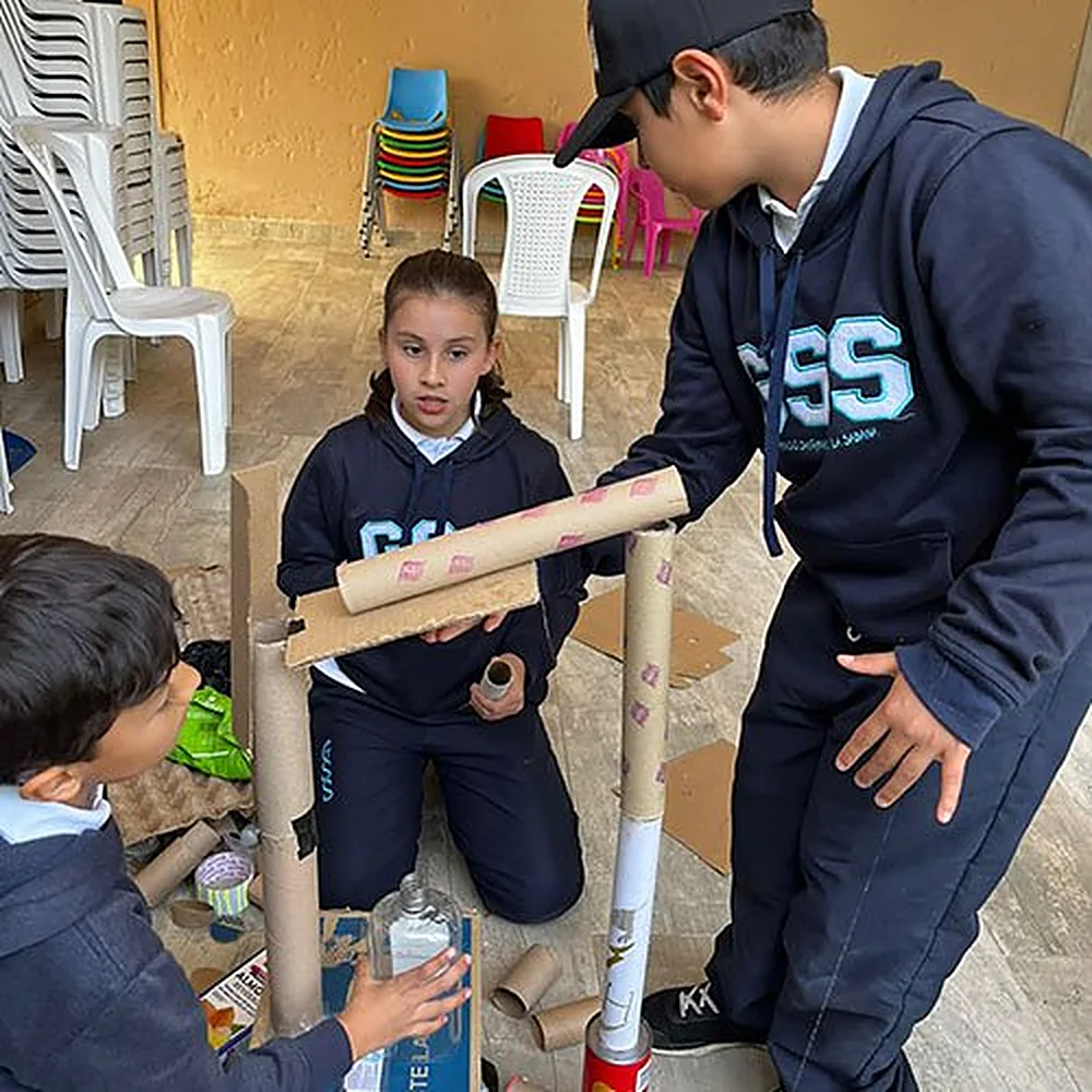 Estudiantes armando una estructura con tubos de cartón