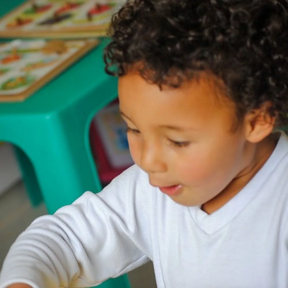 Niño de preescolar concentrado en una actividad sobre la mesa