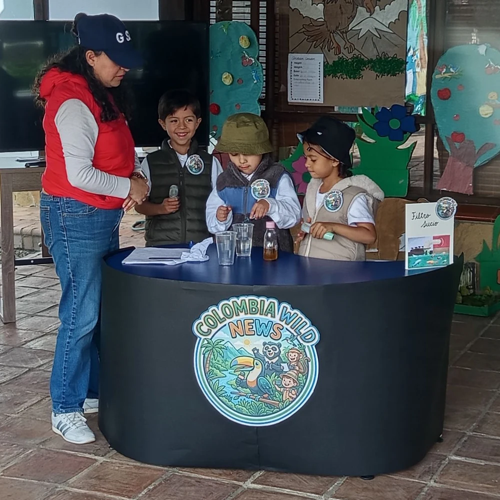 Niños de preescolar atendiendo el puesto de su proyecto junto a su profesora