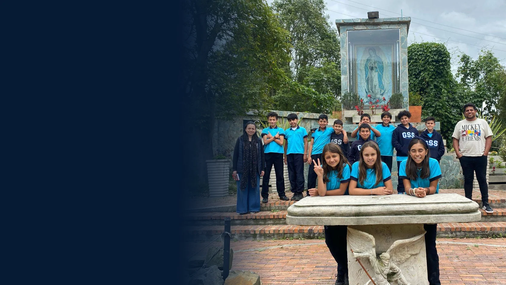 Estudiantes de primaria con el uniforme del colegio, frente a un santuario de la Virgen de Guadalupe